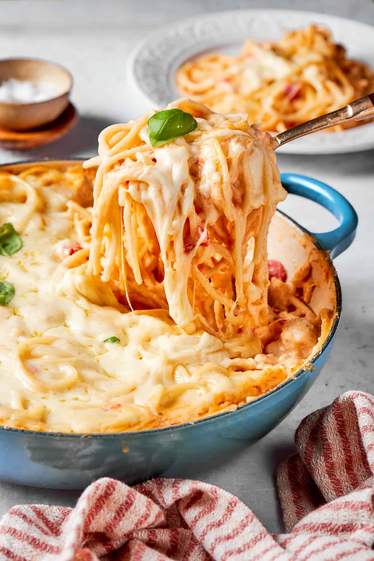 A serving utensil lifts out a potion of cheesy chicken spaghetti.