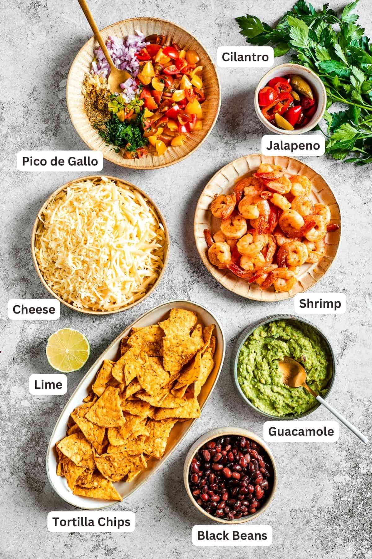 Ingredients for shrimp nachos are shown: tortilla chips, pico de Gallo, guacamole, shrimp, lime, cheese, jalapeno.