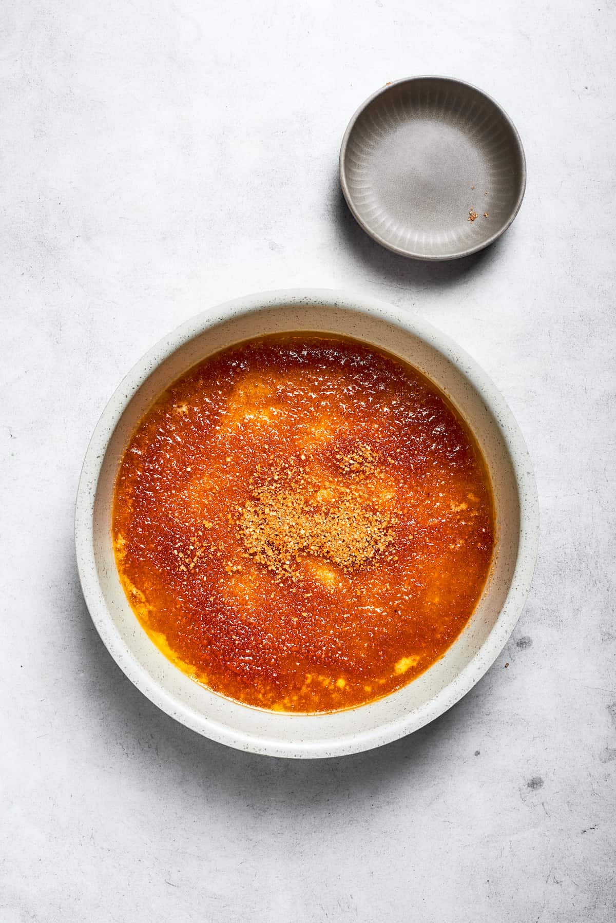 Melted butter and brown sugar are combined and swirled in the bottom of a round cake pan, forming the caramel base.