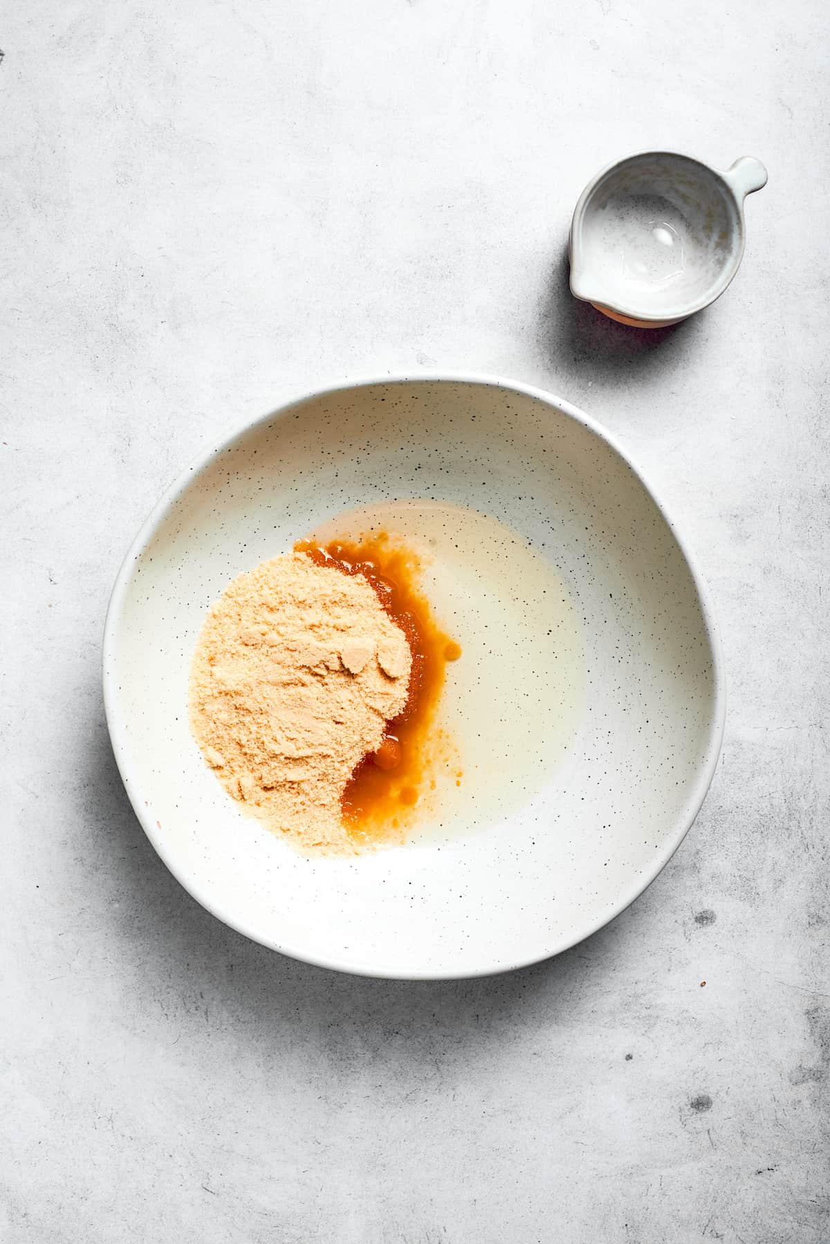 Vegetable oil and granulated sugar are added to a mixing bowl, ready to be combined for the wet ingredients.