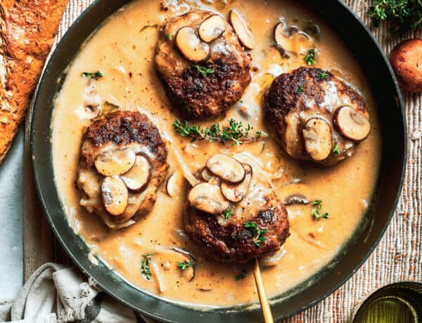 Four pieces of chopped steak are added to a pan with gravy.