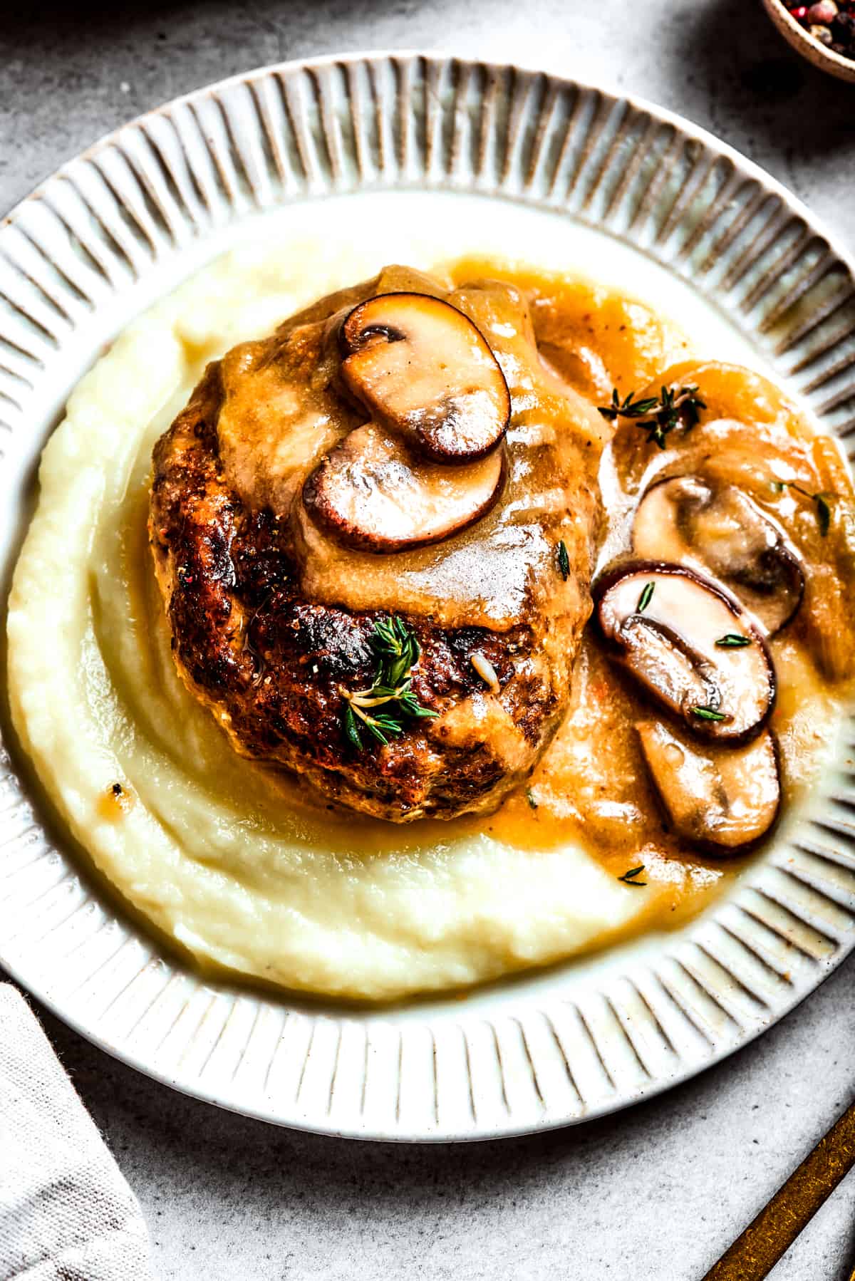 A serving of chopped steak served over mashed potatoes.
