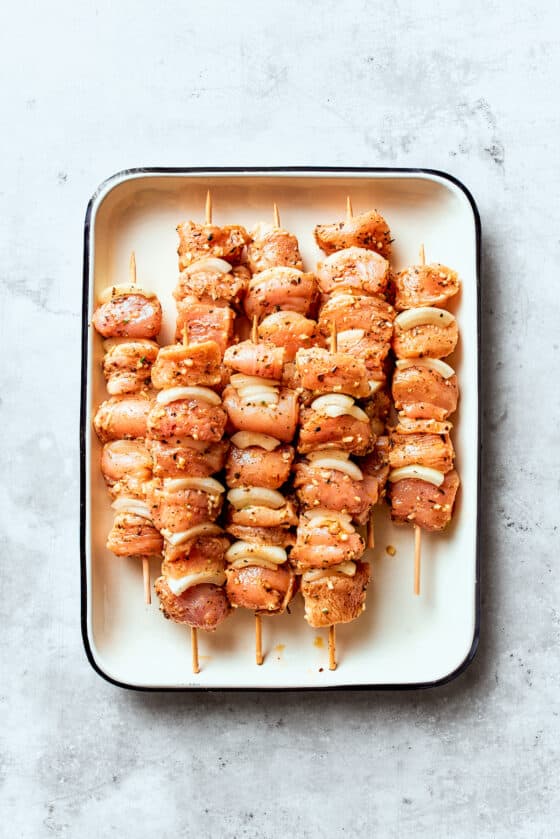 The chicken is threaded onto skewers.