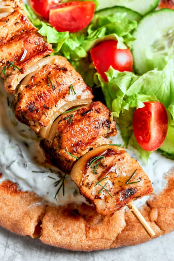 A close up of chicken souvlaki on top of bread.