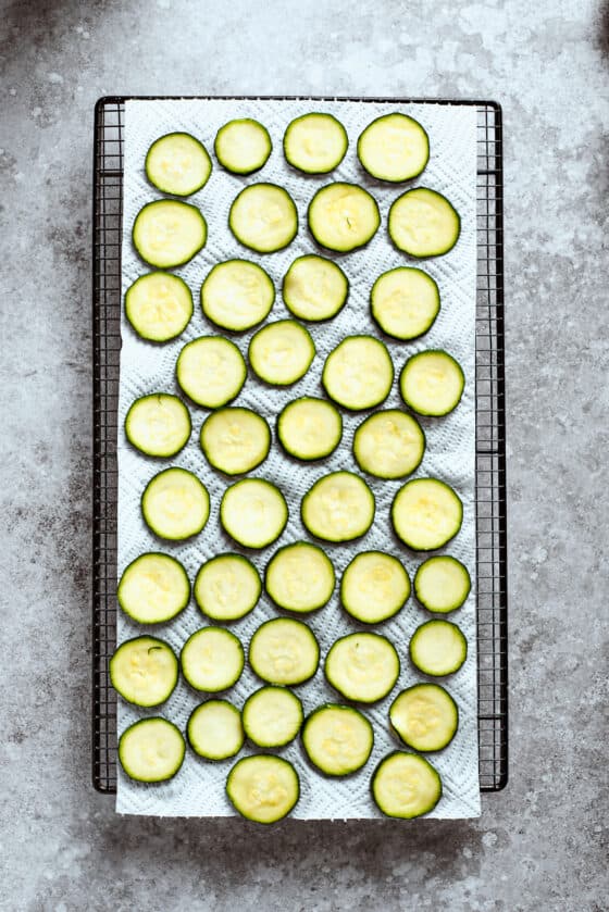 A large baking sheet full of slices of zucchini.