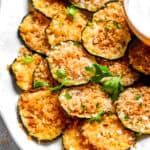 A pile of zucchini chips arranged on a plate.