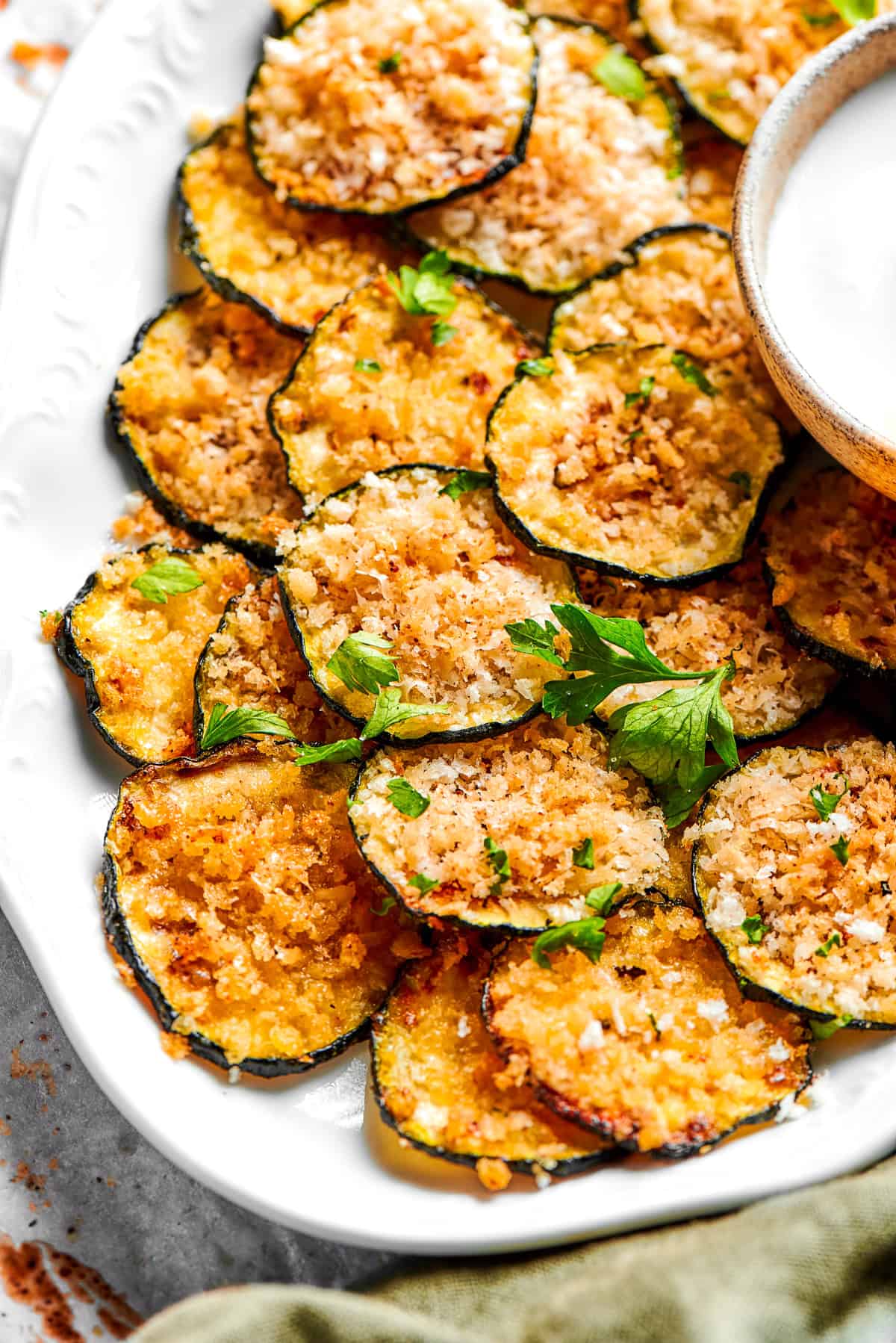 A pile of zucchini chips arranged on a plate.