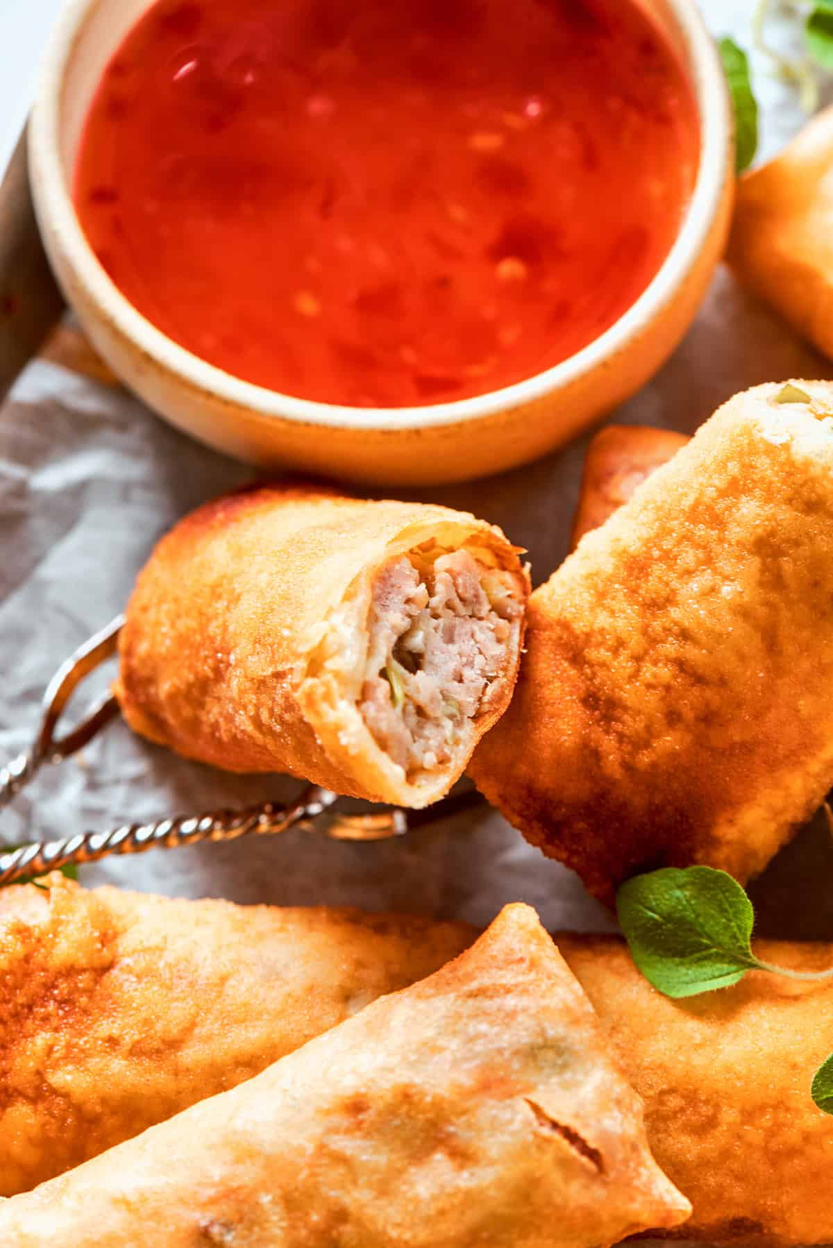 Crisp chicken egg rolls and a bowl of red sauce.