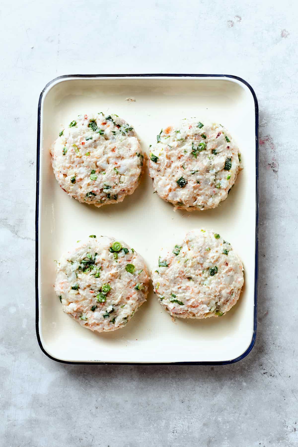 Four formed shrimp patties on a try.