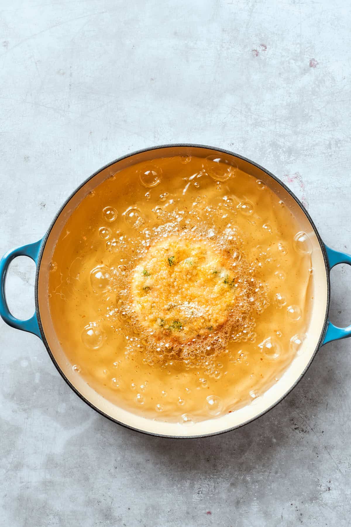 A shrimp patty fries in oil.