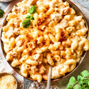 Stirring through macaroni and cheese in a skillet.