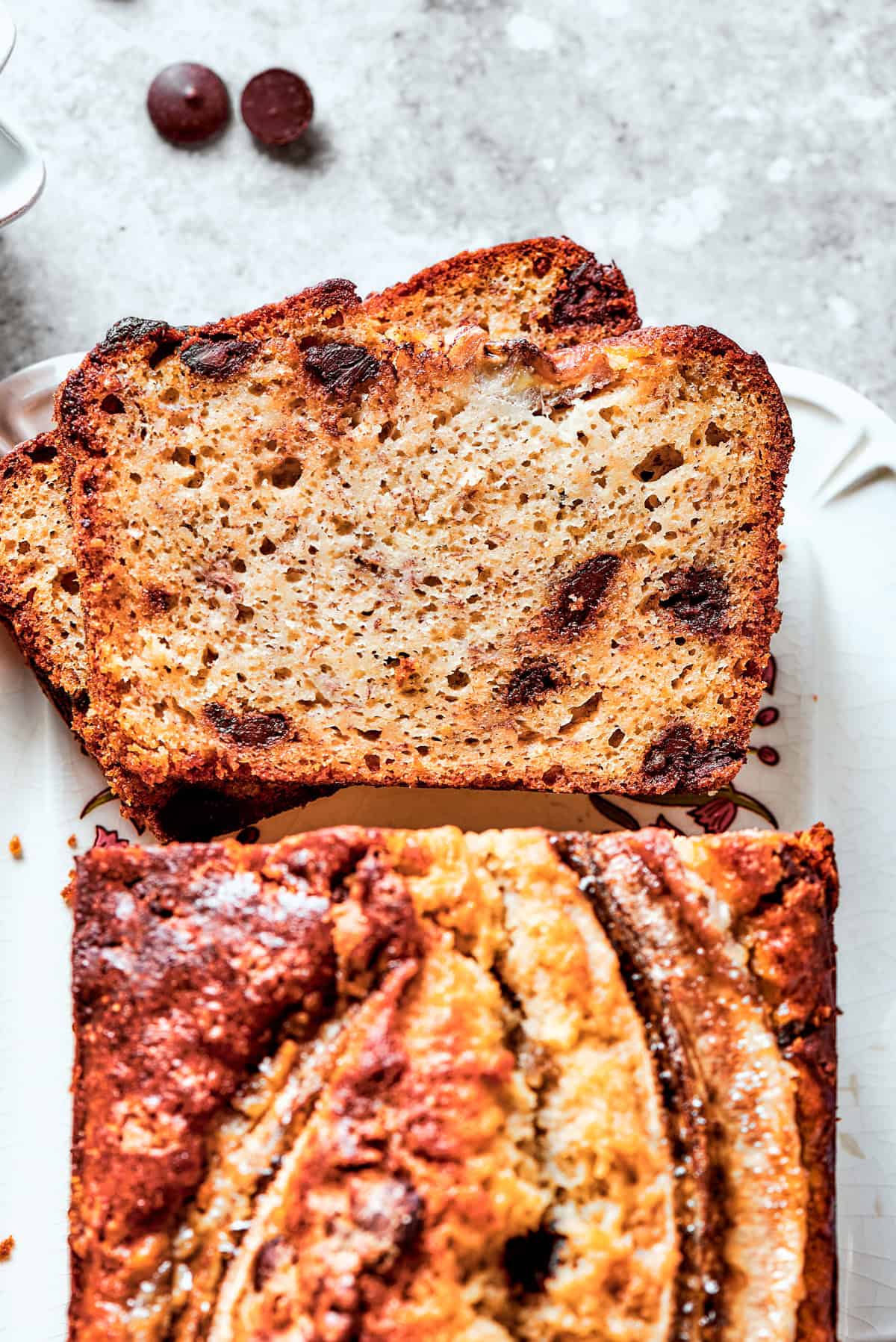 Overhead view of banana bread and two slices cut out from it.