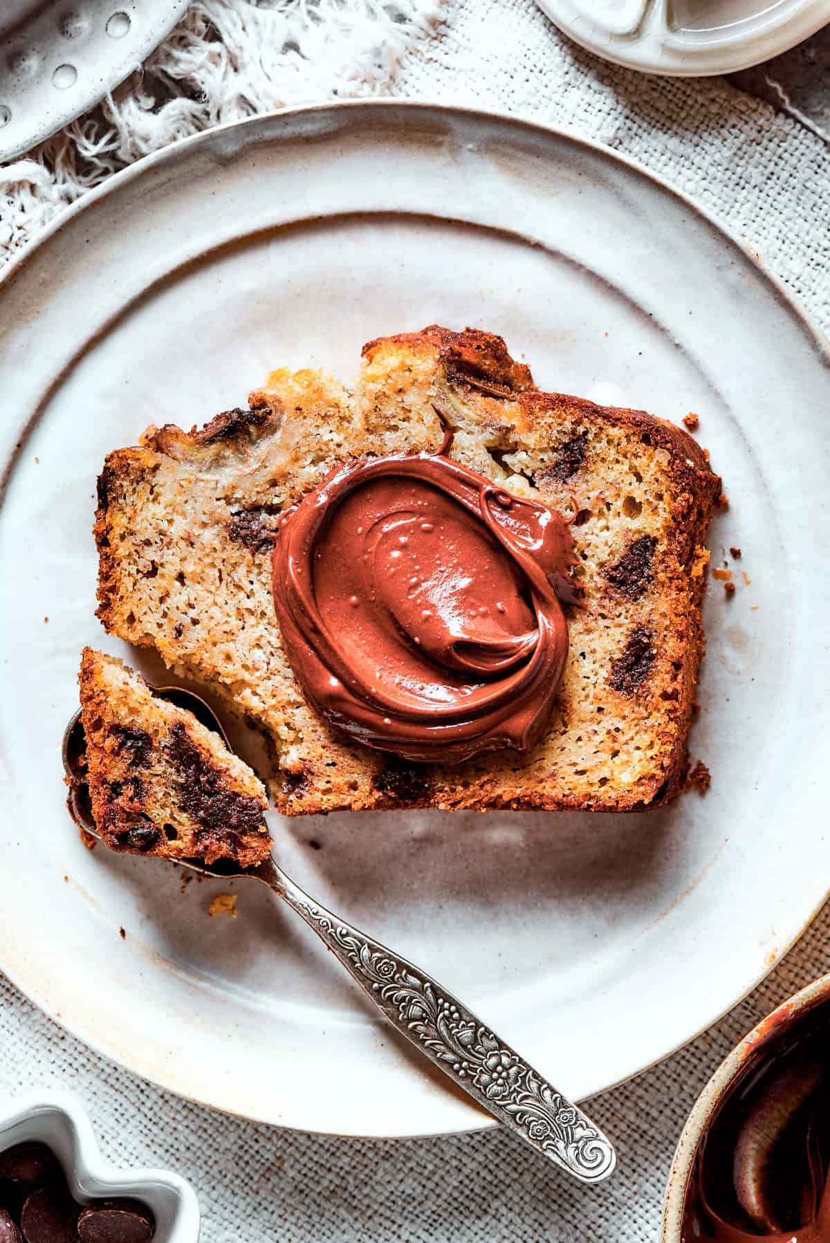 Spreading nutella over a slice of banana bread.