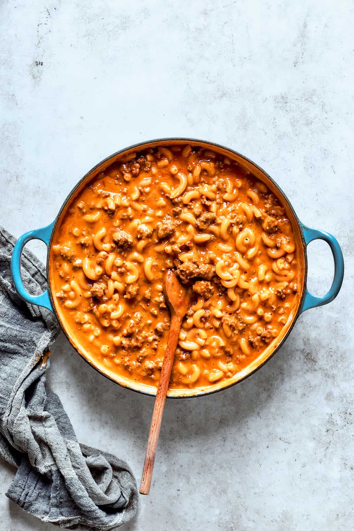 Cheese and heavy cream are stirred into the pot of hamburger helped.