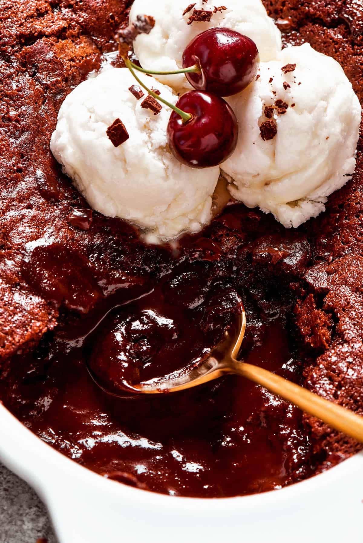 Close-up image of a spoon stirring through chocolate pudding cake.