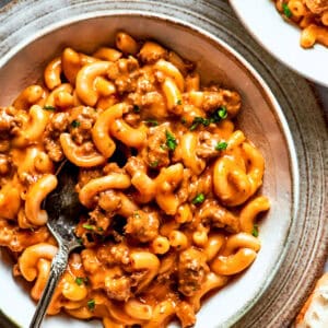 A bowl of macaroni tossed with beef sauce.