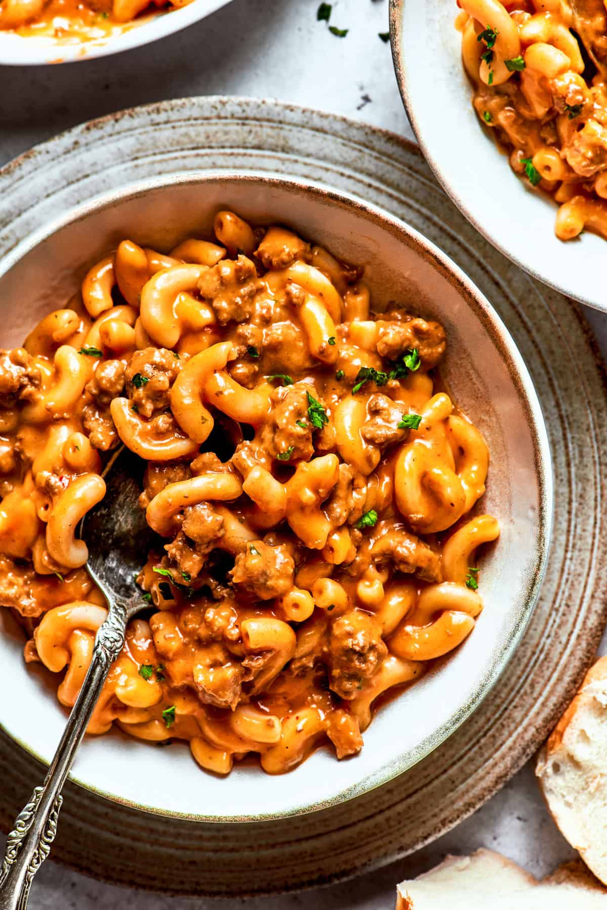 A bowl of macaroni tossed with beef sauce.