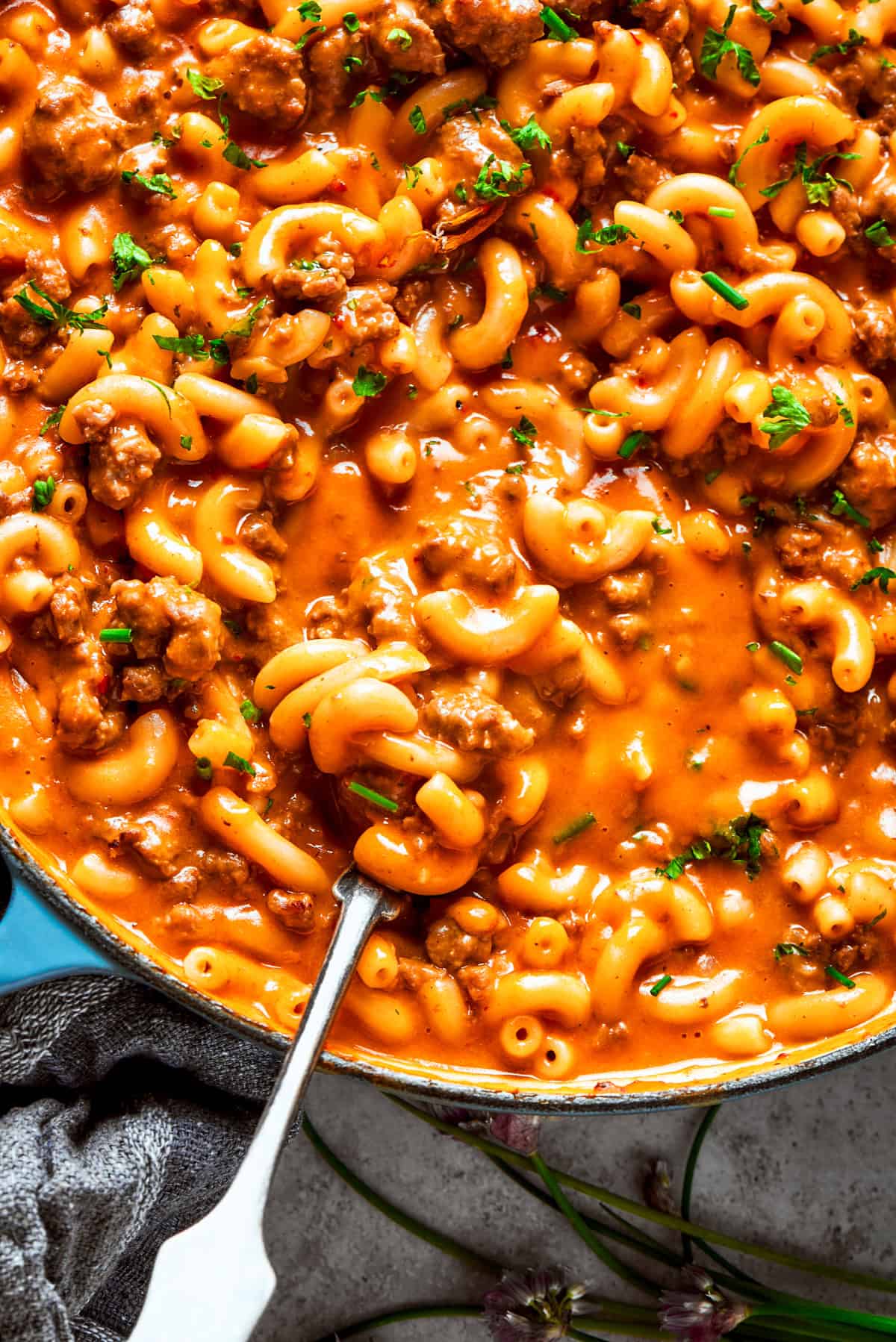 Spoon stirring through homemade hamburger helper in a skillet.