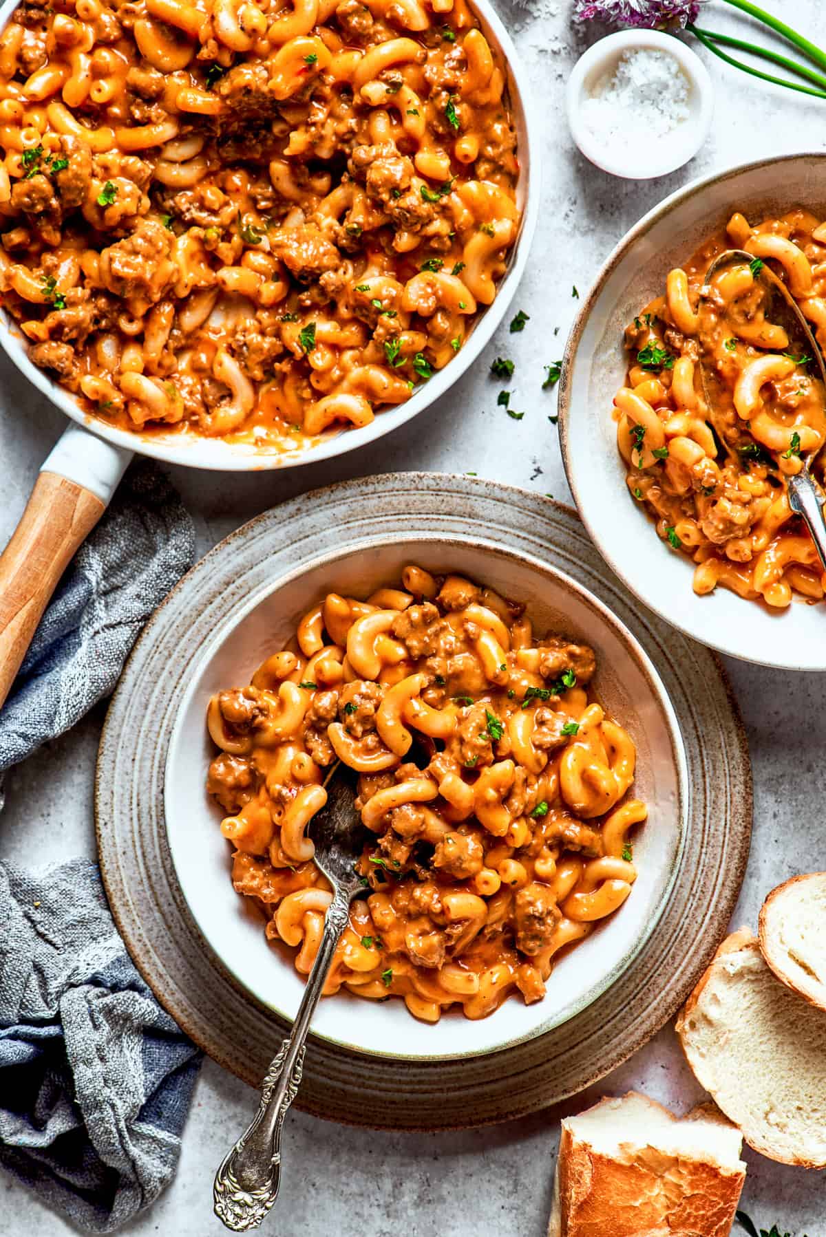 Hamburger helper served in bowls, with a spoon stirring through the pasta.