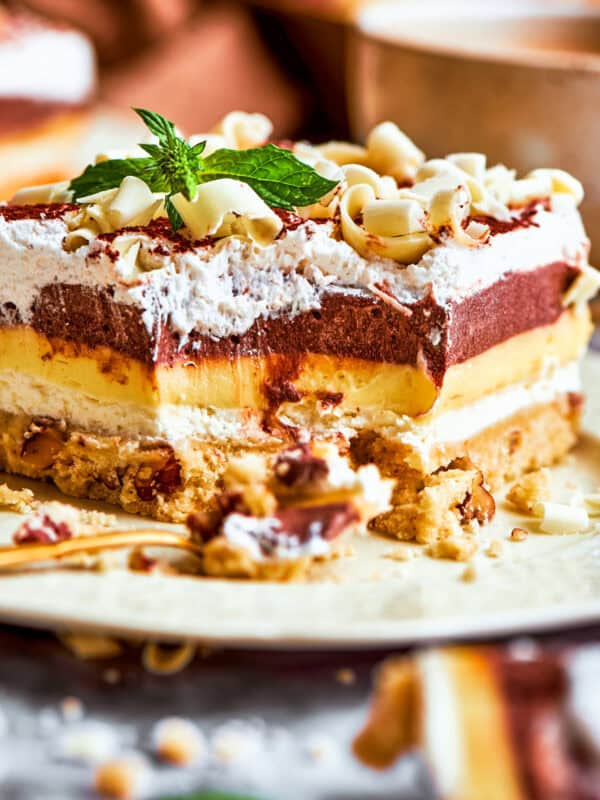 A side view of sex in a pan dessert with all the layers showing.