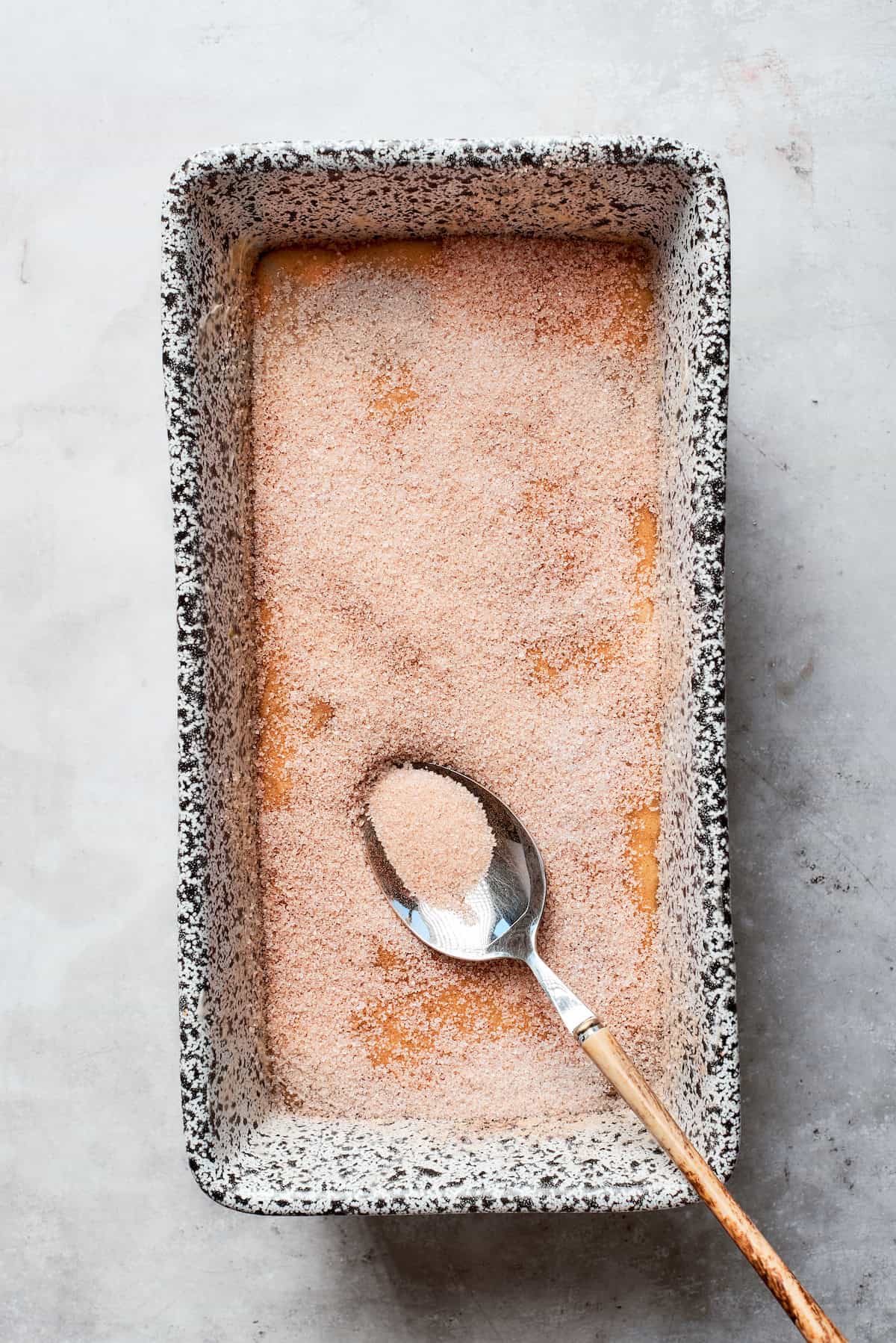 Sugar is added to the top of the batter in the pan.