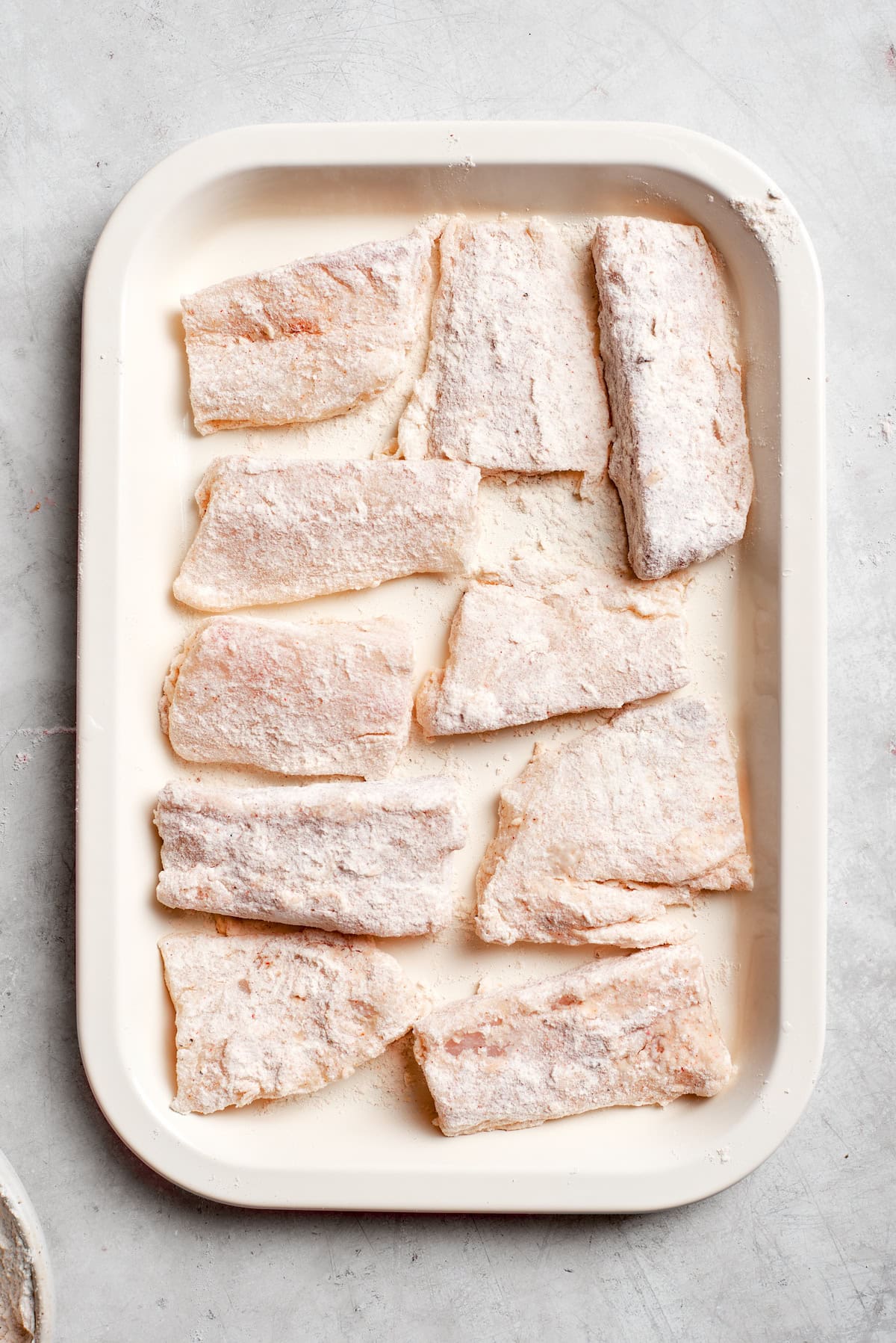 Pieces of fish on a baking tray.