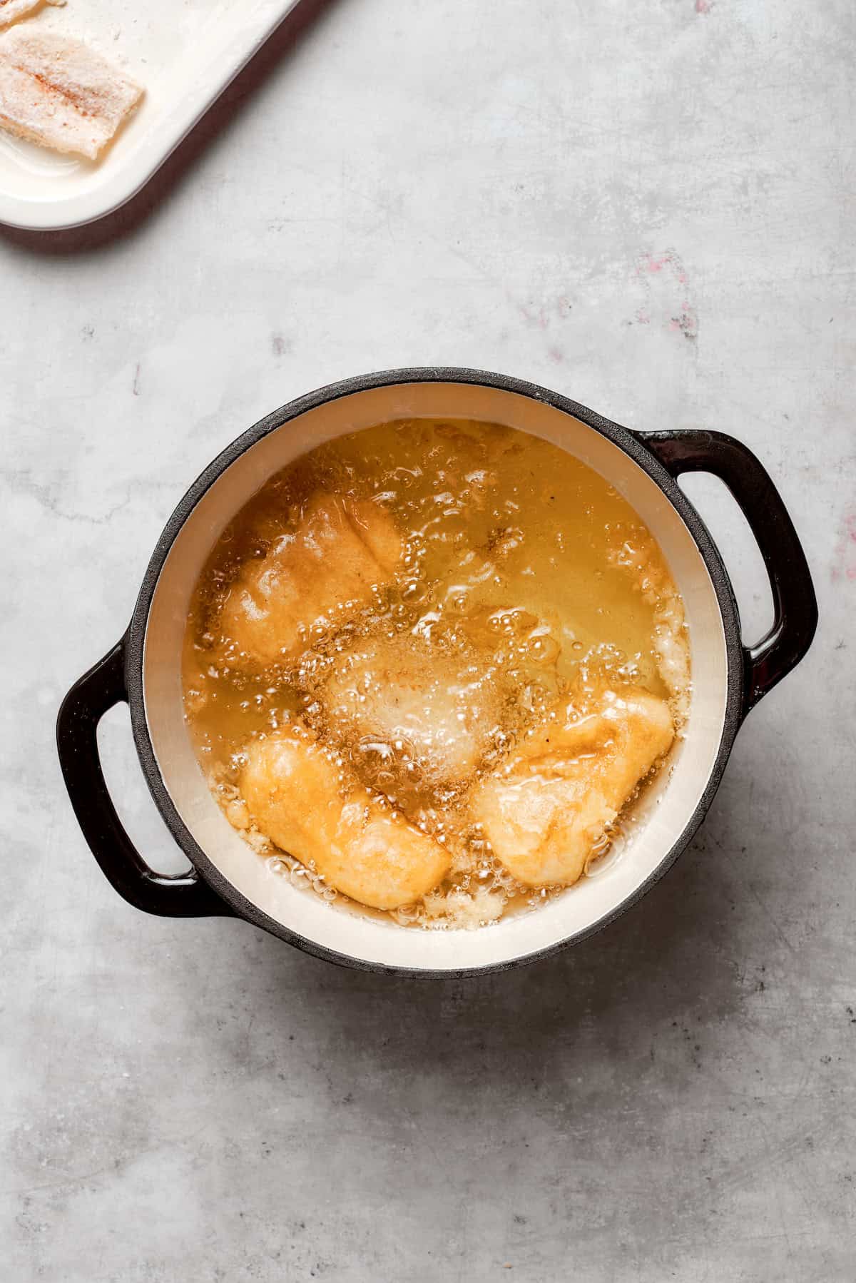 Fish fries in a pot of oil.