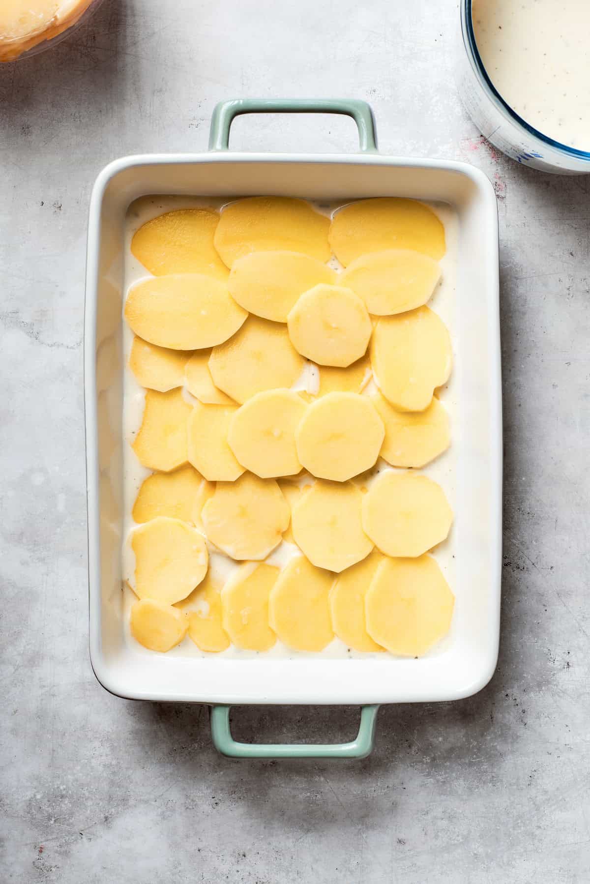 Sliced potatoes on the bottom of the pan.