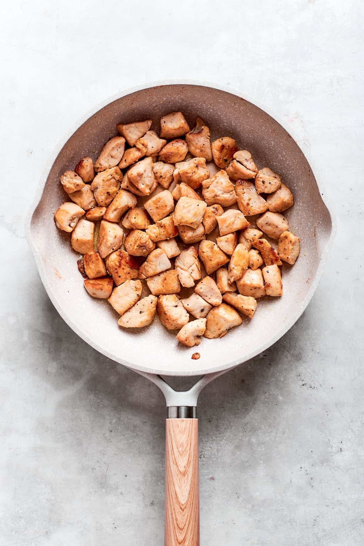 Chicken pieces are browned in a skillet for teriyaki chicken recipe.