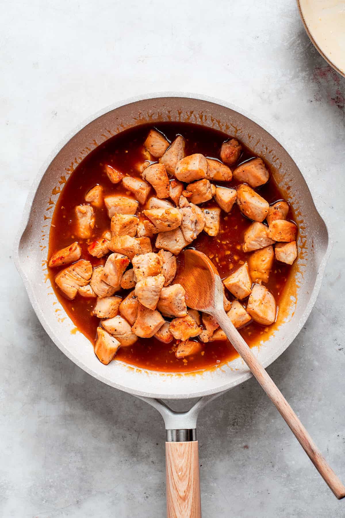 The chicken is added back to the pan of sauce.