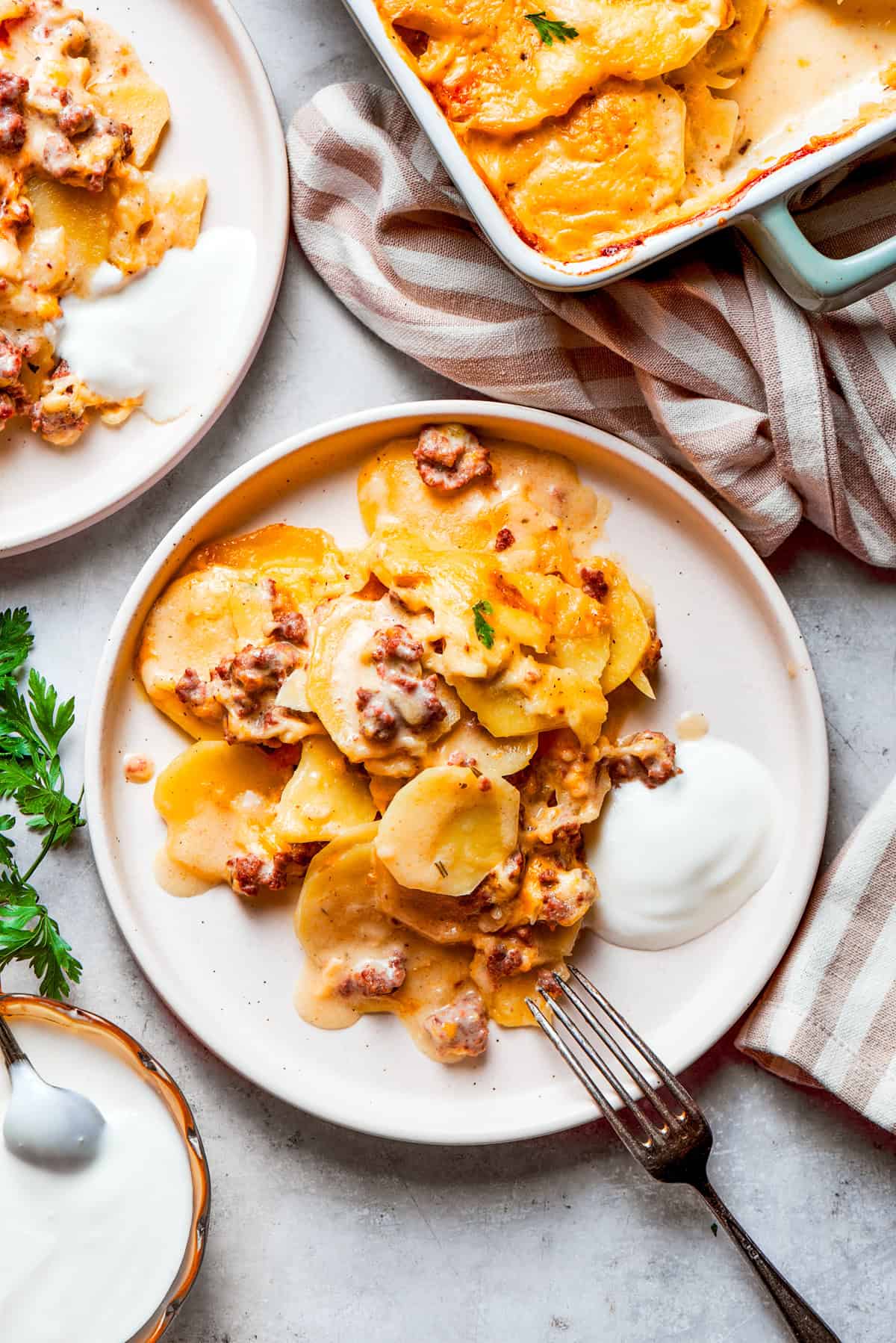 A portion of hamburger potato casserole served on dinner plates.