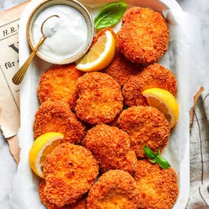 A serving tray with homemade chicken nuggets and a dish of ranch dressing and lemon slices.