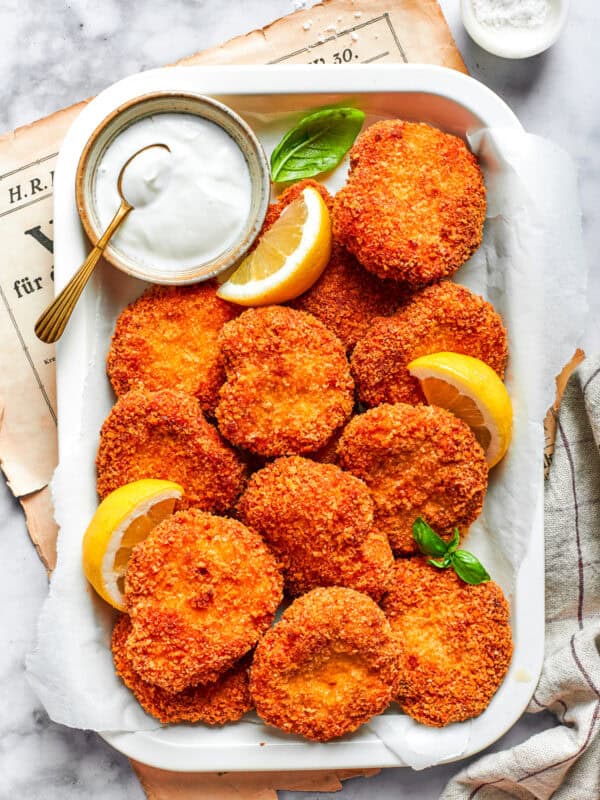 A serving tray with homemade chicken nuggets and a dish of ranch dressing and lemon slices.