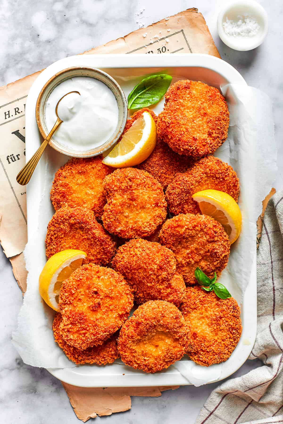 A serving tray with homemade chicken nuggets and a dish of ranch dressing and lemon slices.