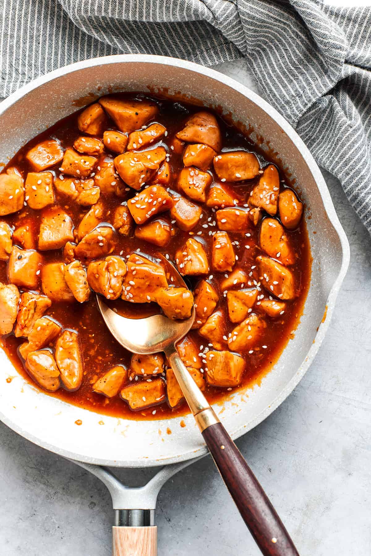 Cubes of chicken cooking in a sauce.