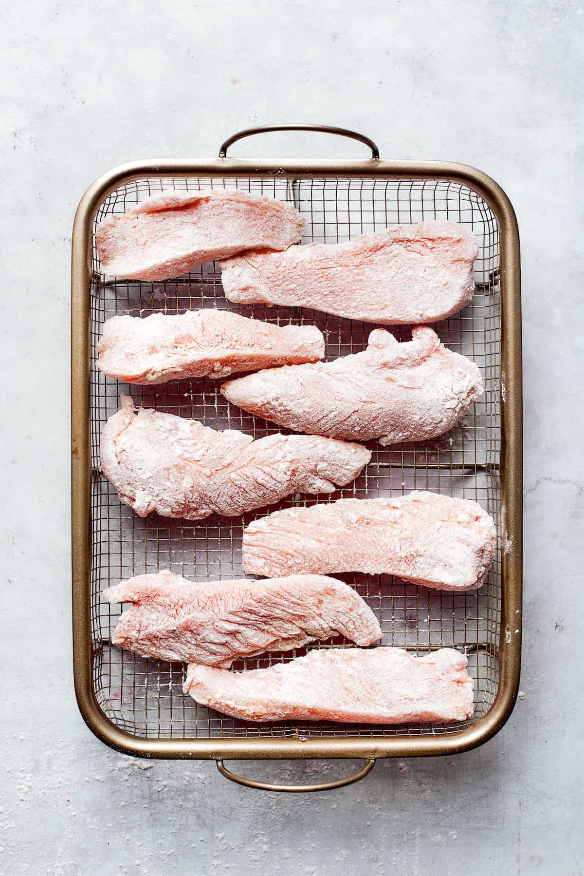 Pieces of chicken on a wire rack.