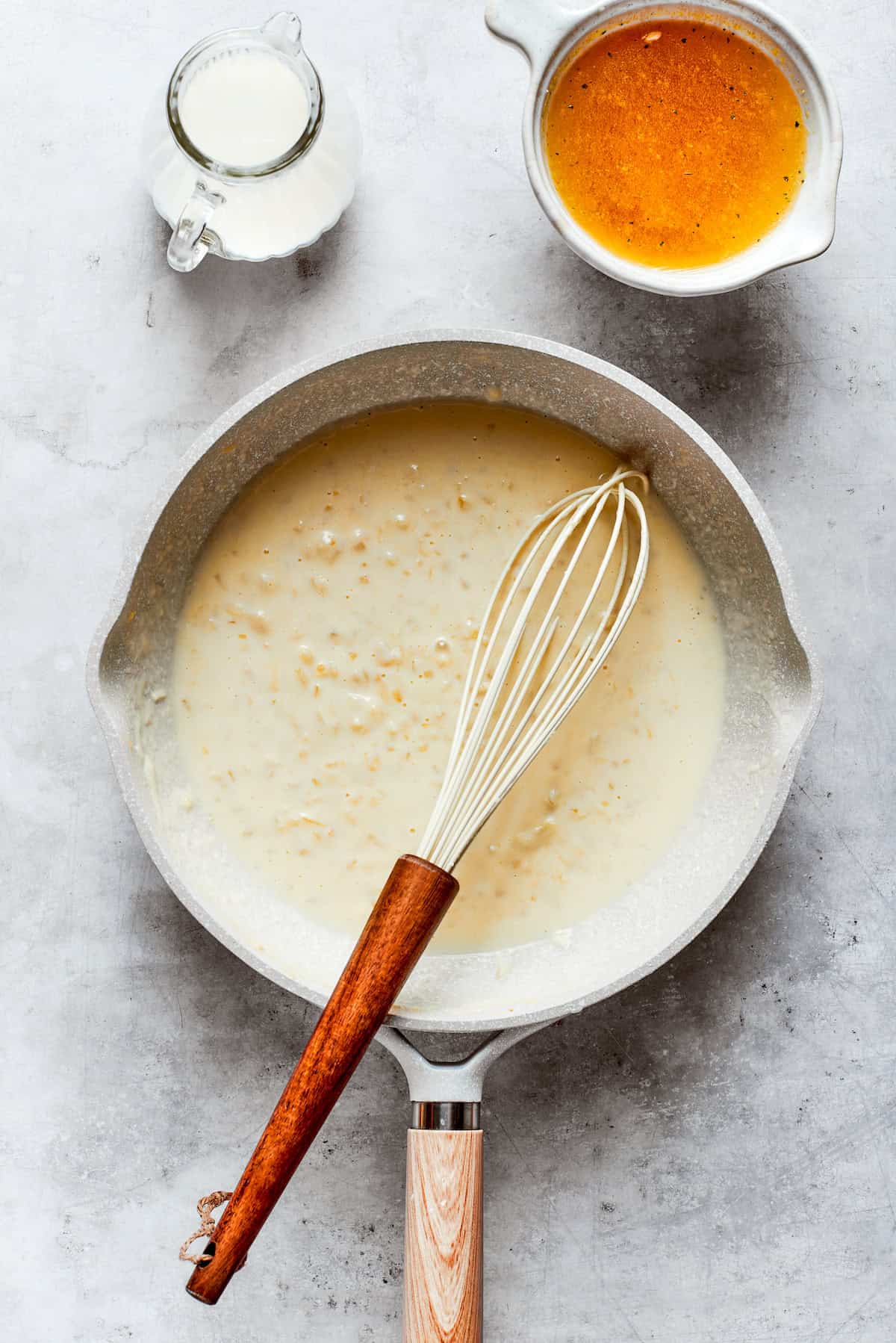 Cheese sauce is whisked in a pot.