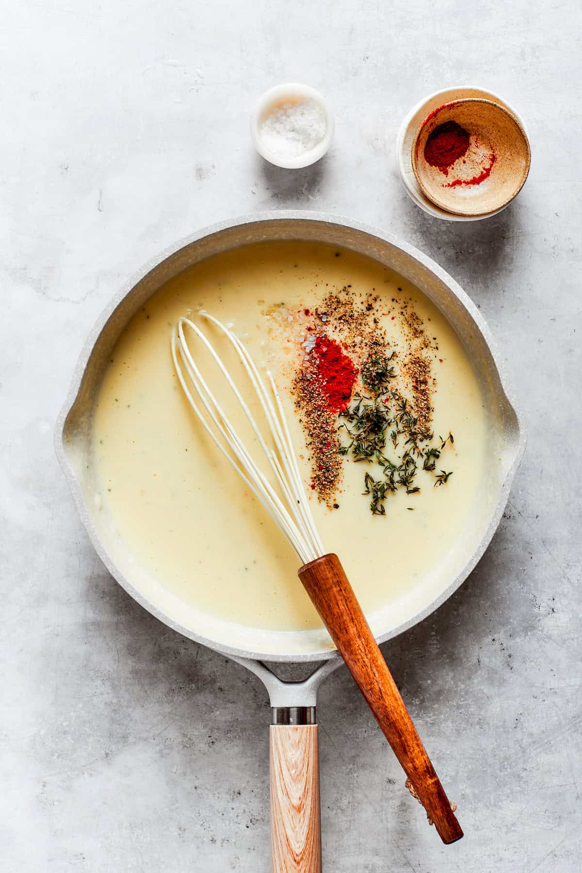 Seasonings are added to roux in a pot.