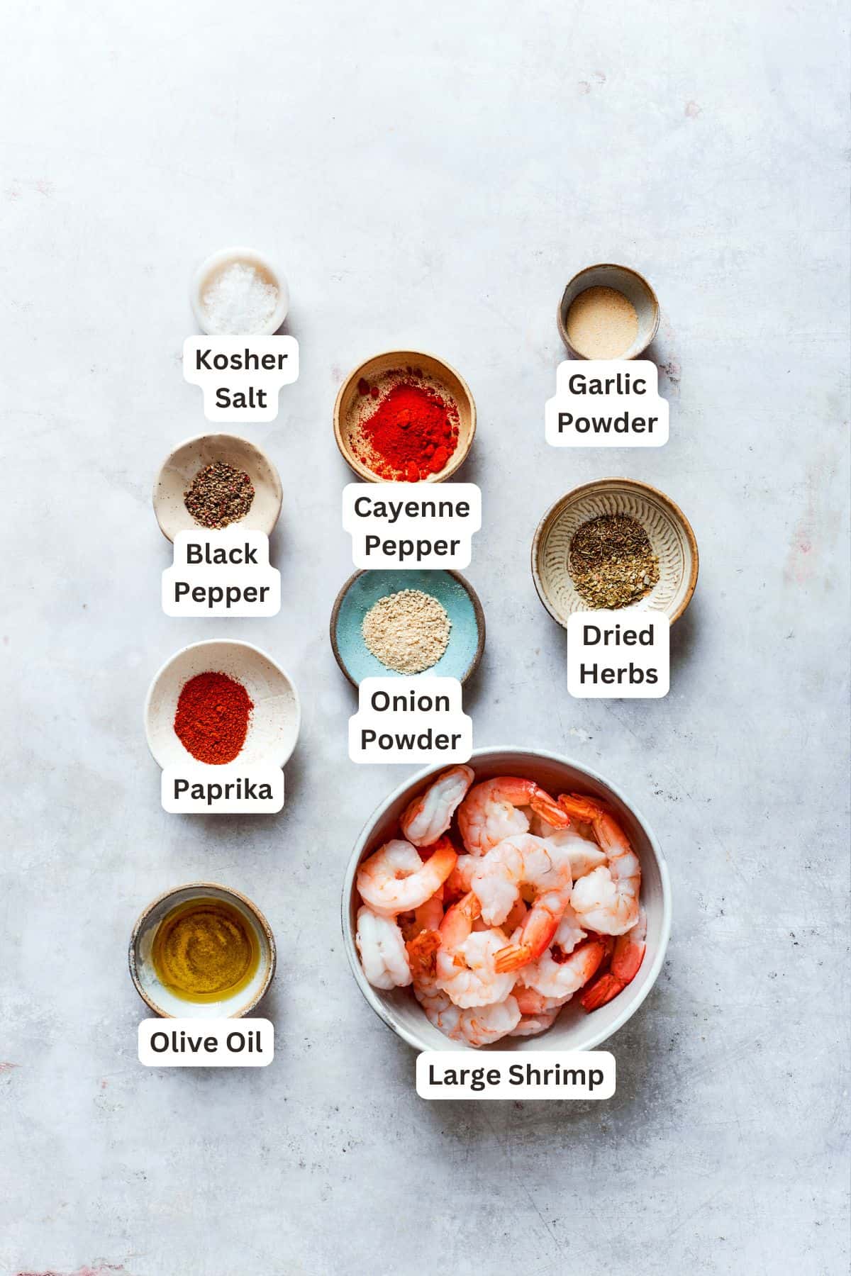 Labeled ingredients for cajun shrimp include black pepper, cayenne pepper, salt, garlic powder, dried herbs, onion powder, paprika, olive oil, shrimp.