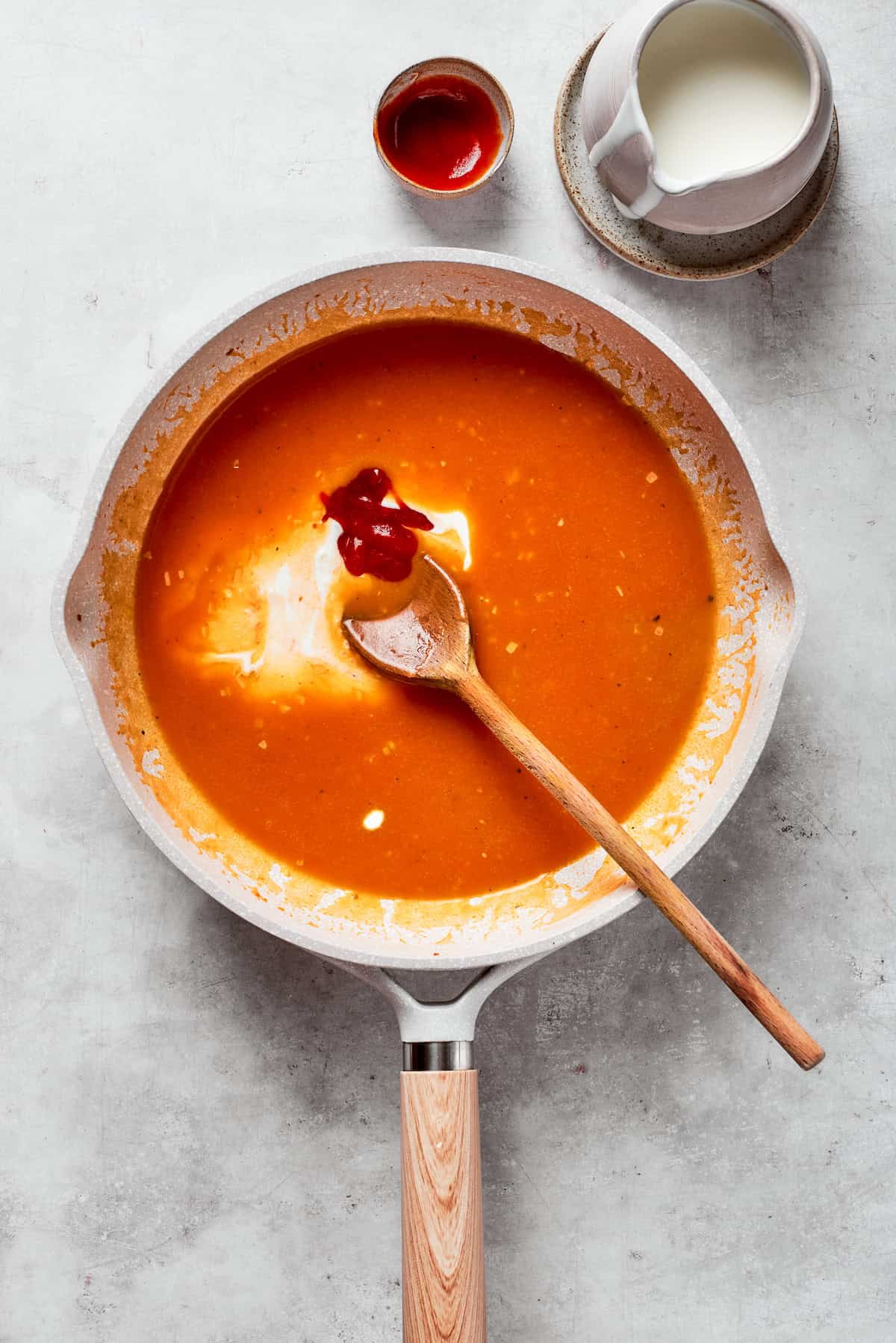 Cream is stirred into a tomato sauce.