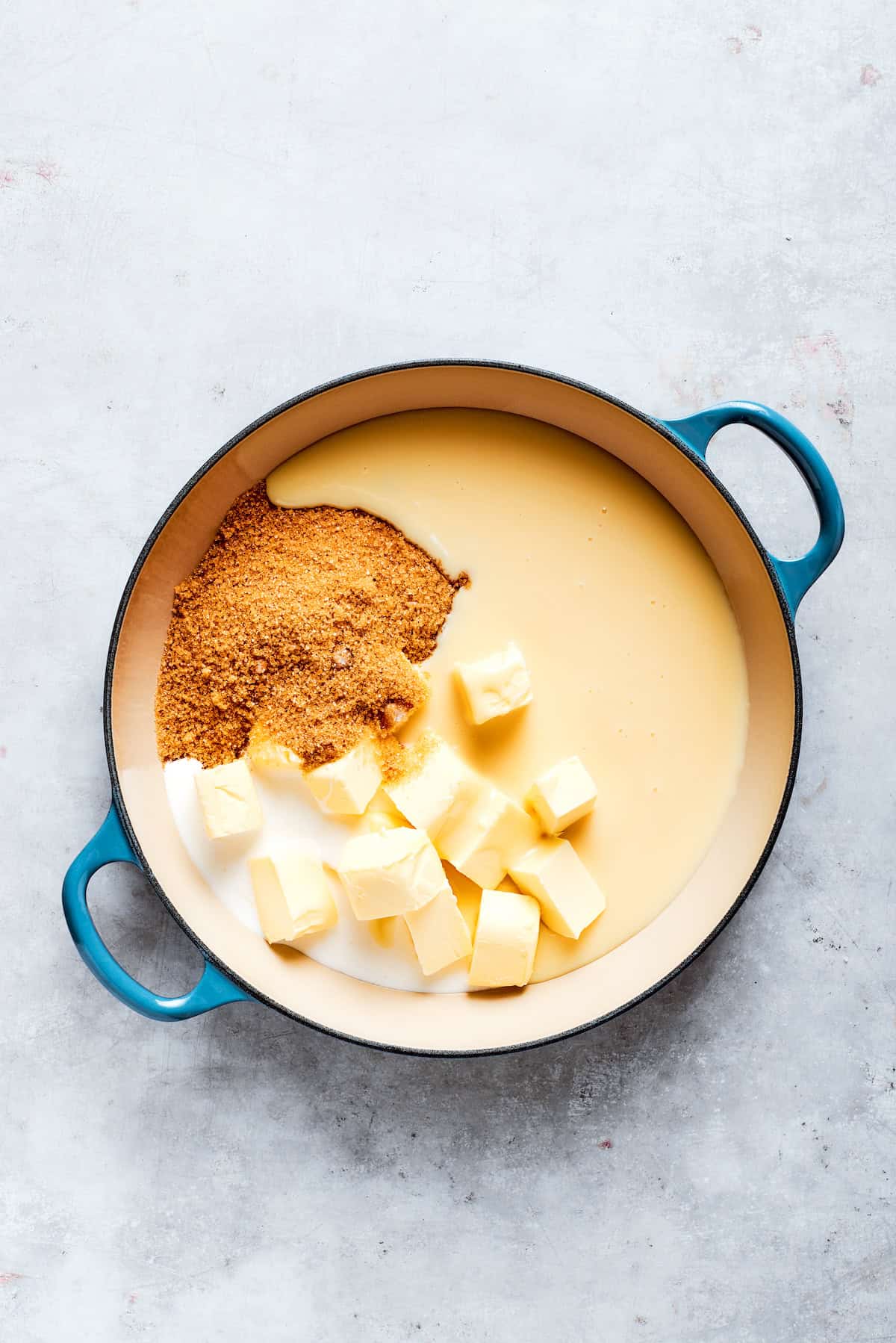 Butter, brown sugar, condensed milk, vanilla, and cream are combined in a pot.