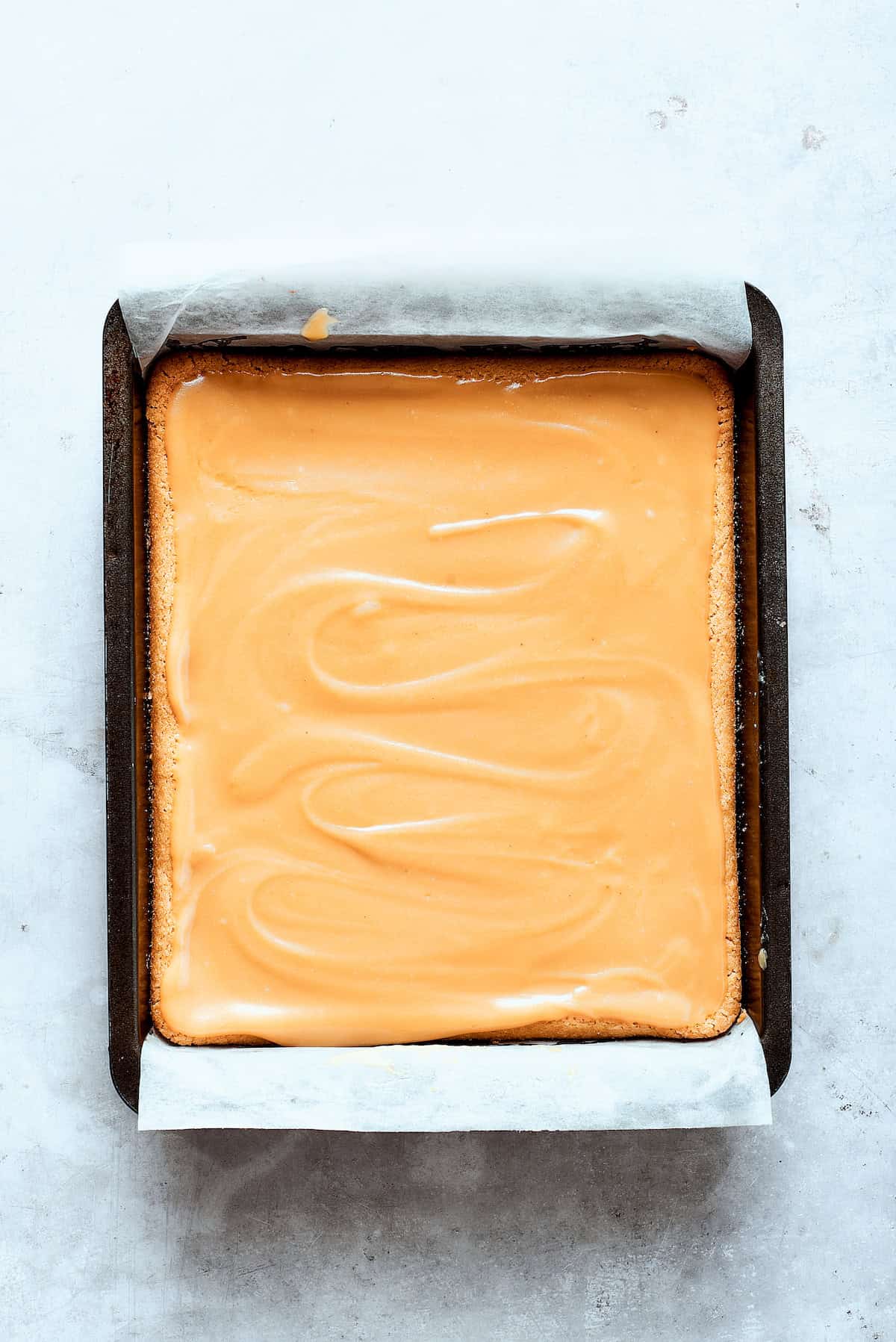 Caramel sauce is added to the shortbread.