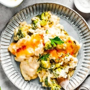 A serving of broccoli & rice casserole on a blue plate with a fork.