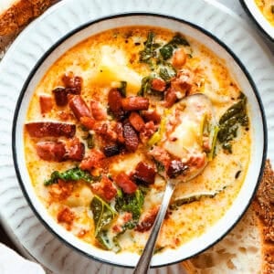 A bowl of zuppa Toscana served in a bowl and garnished with crumbled bacon.