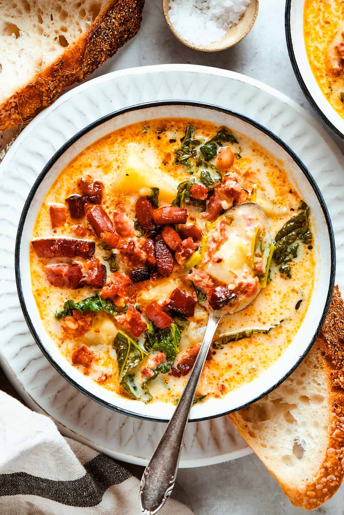 A bowl of zuppa Toscana served in a bowl and garnished with crumbled bacon.