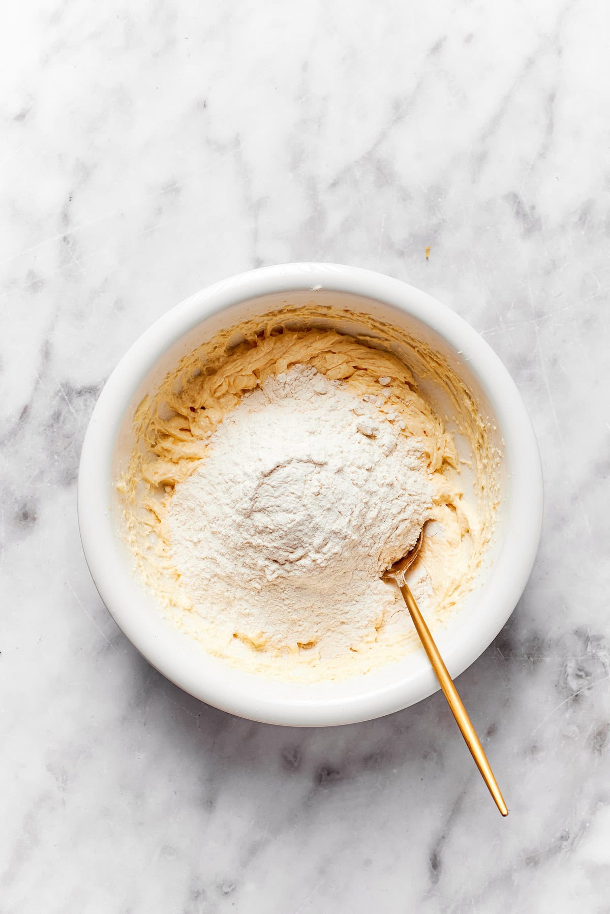 Flour is stirred into a bowl of anginetti cookie dough.