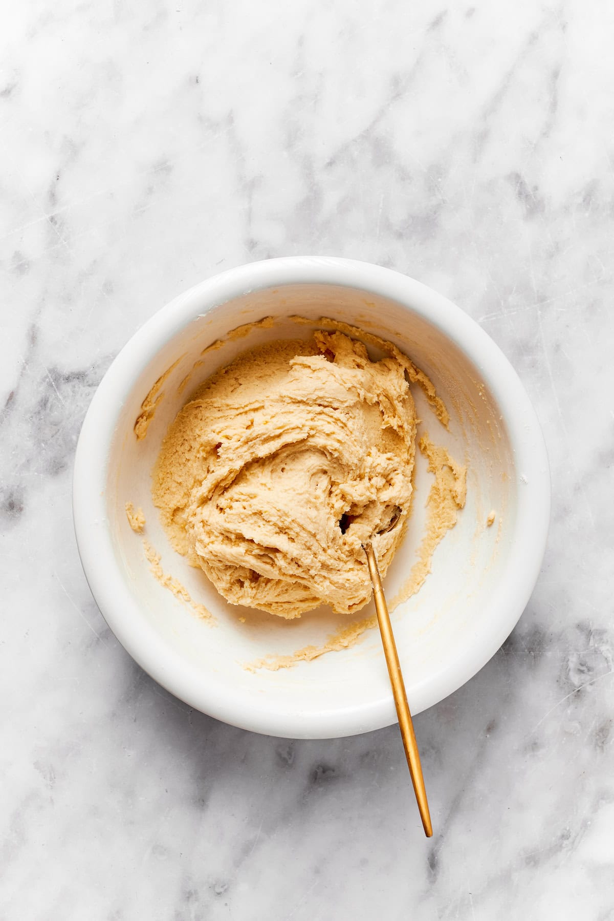 A bowl of anginetti cookie dough with a spoon.