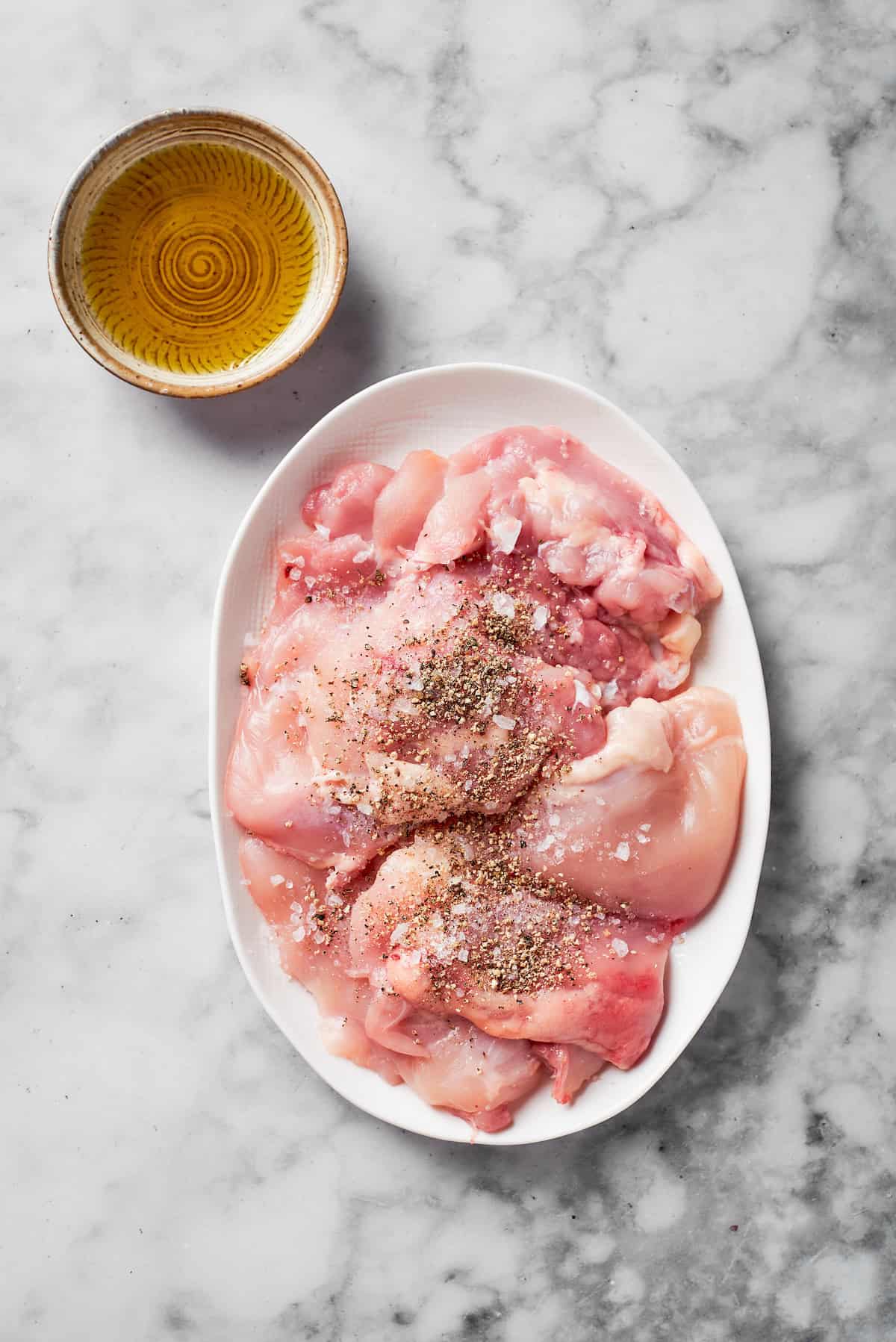 Seasoned chicken breasts on a plate.