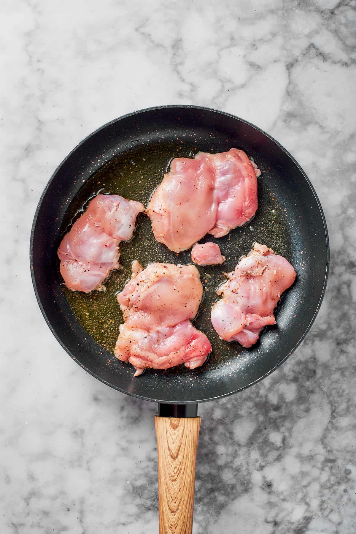 Cooking chicken in a skillet.