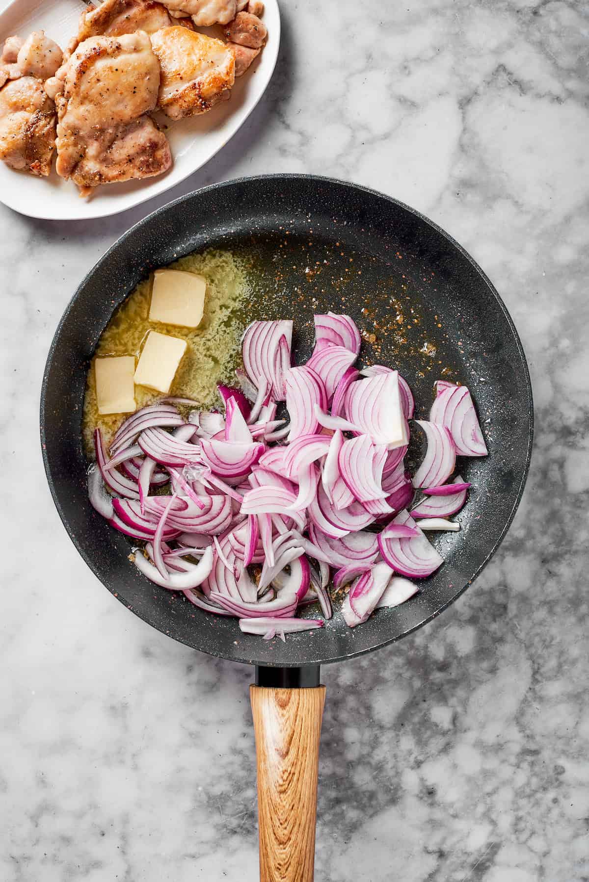 Red onions and butter in a pan.